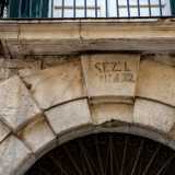 In alto notiamo una sbiadita scritta nera che riporta le vecchie suddivisioni catastali della citt�